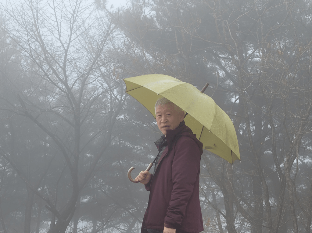 광교산 헬기장 정상에서 비를 맞으며 여유있는 친구의 사진입니다